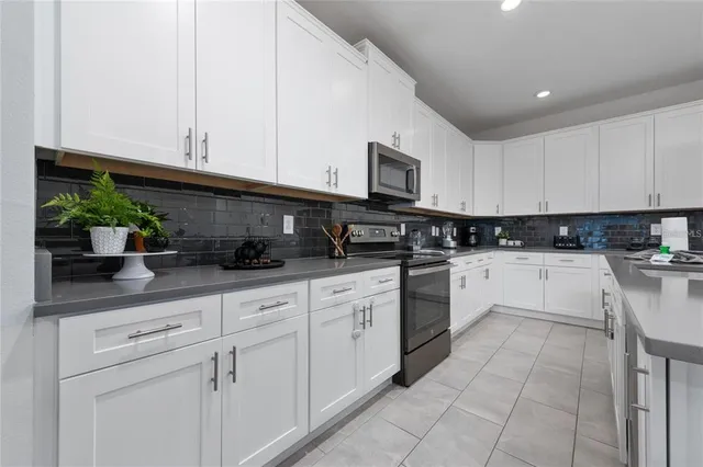a kitchen with stainless steel appliances granite countertop white cabinets sink and dishwasher