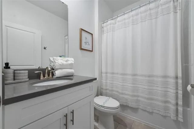 a bathroom with a granite countertop sink a toilet and shower
