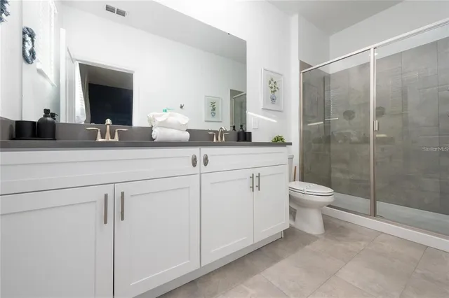 a bathroom with a double vanity sink toilet and shower