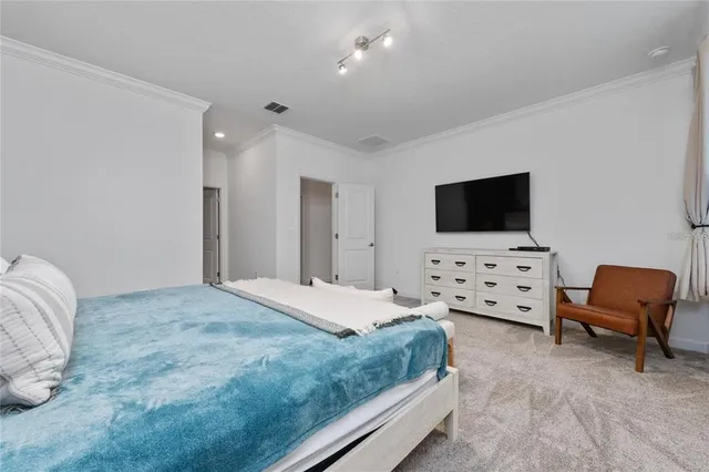 a bedroom with bed and tv with wooden floor