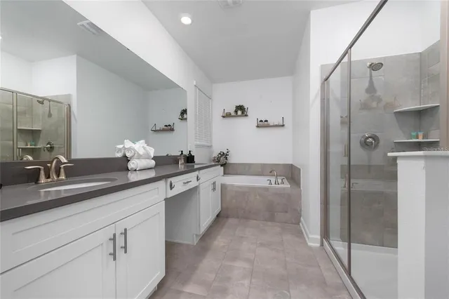 a spacious bathroom with a granite countertop sink mirror and bathtub