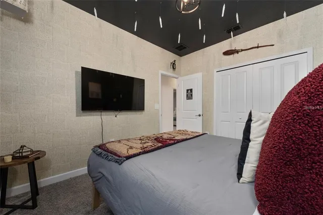 a bedroom with a bed and a flat screen tv