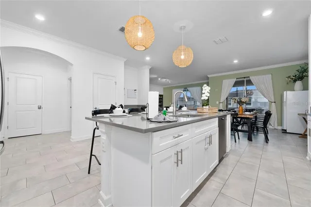 a kitchen with kitchen island granite countertop lots of white cabinets appliances and dining table
