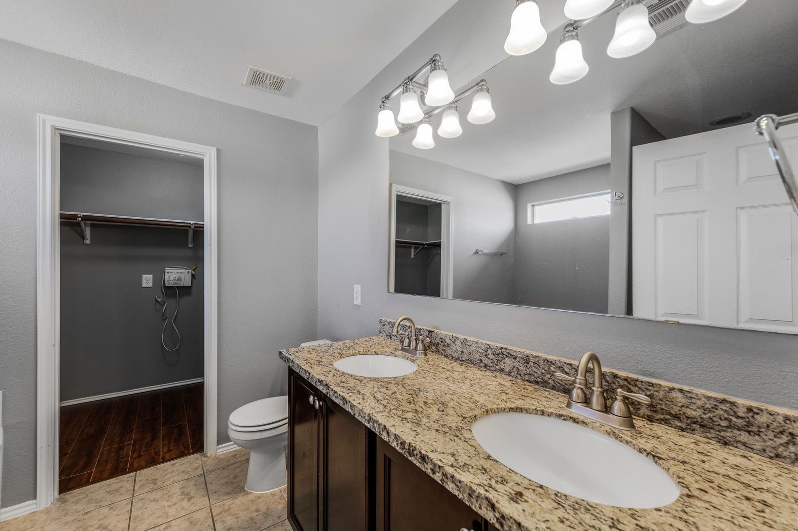 21310 Bandera Ranch Lane Katy, TX 77449 - Photo 22 of 39 a bathroom with a granite countertop sink a toilet and a mirror
