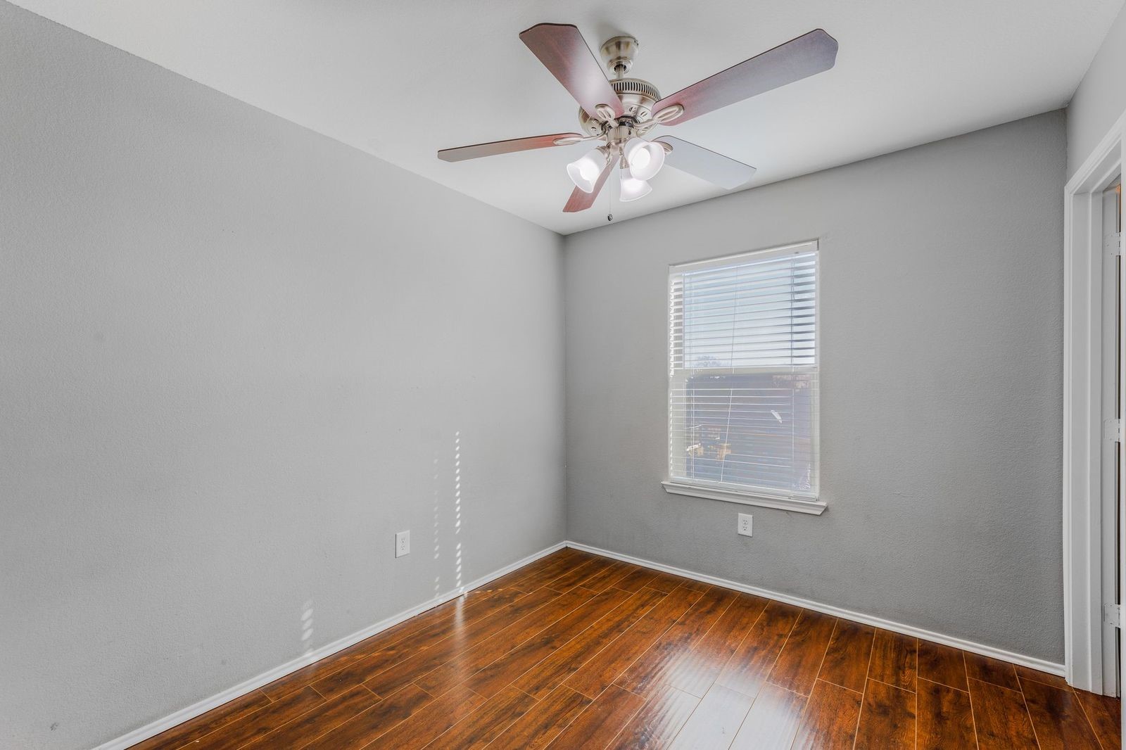 21310 Bandera Ranch Lane Katy, TX 77449 - Photo 27 of 39 an empty room with wooden floor chandelier fan and windows