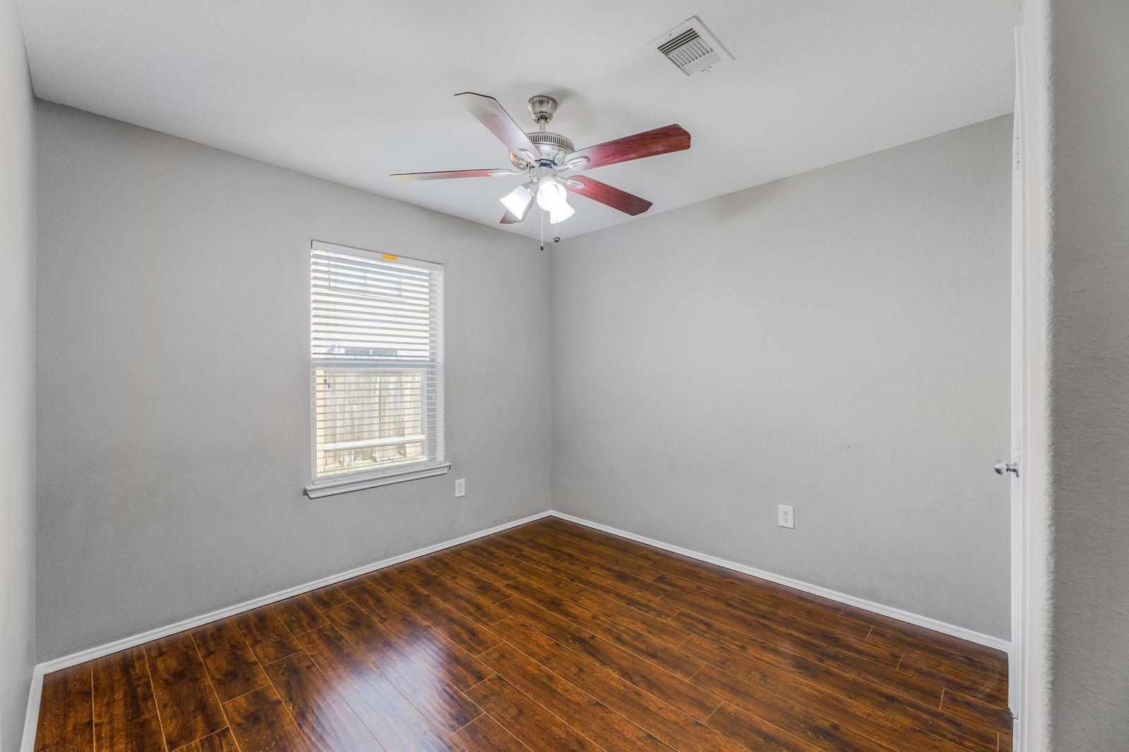 21310 Bandera Ranch Lane Katy, TX 77449 - Photo 29 of 39 an empty room with wooden floor fan and windows