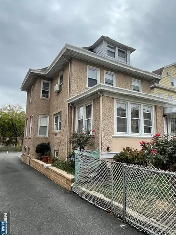 a front view of a house with a lots of windows and plants