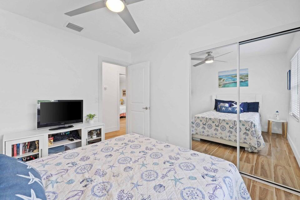 5554 Hibiscus Road Jupiter, FL 33458 - Photo 29 of 70 a bedroom with a bed and a flat tv screen on dresser