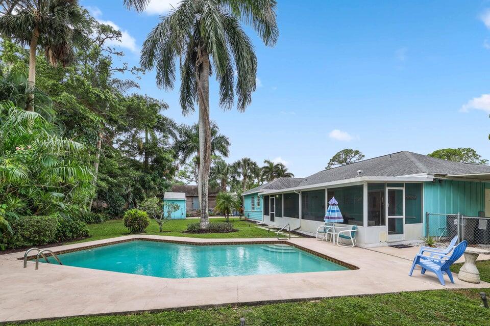 5554 Hibiscus Road Jupiter, FL 33458 - Photo 36 of 70 a view of a house with swimming pool and sitting area