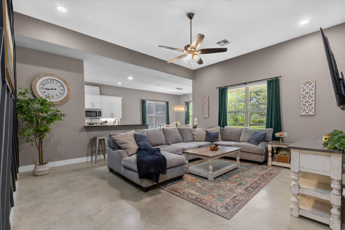 145 Cardinal Loop Paige, TX 78659 - Photo 11 of 40 An inviting open-concept living area with a bright ambiance and a versatile ceiling fan.