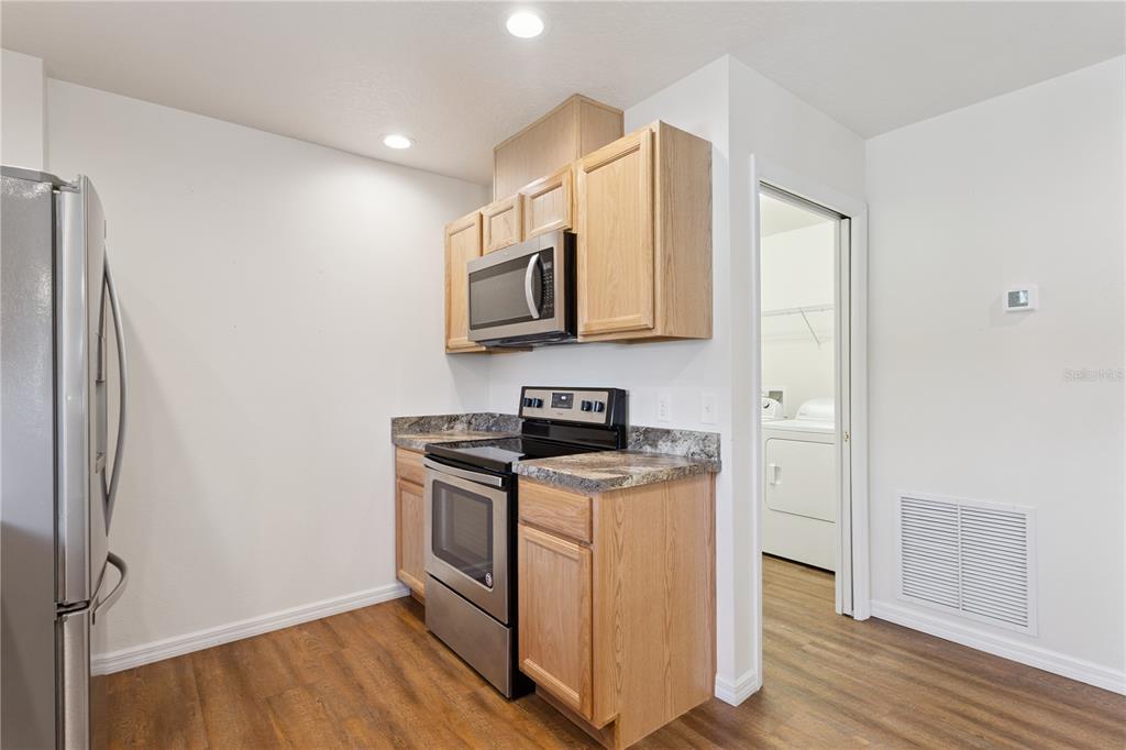 112 Turtle Run Umatilla, FL 32784 - Photo 12 of 32 a kitchen with stainless steel appliances granite countertop a stove a refrigerator and a microwave