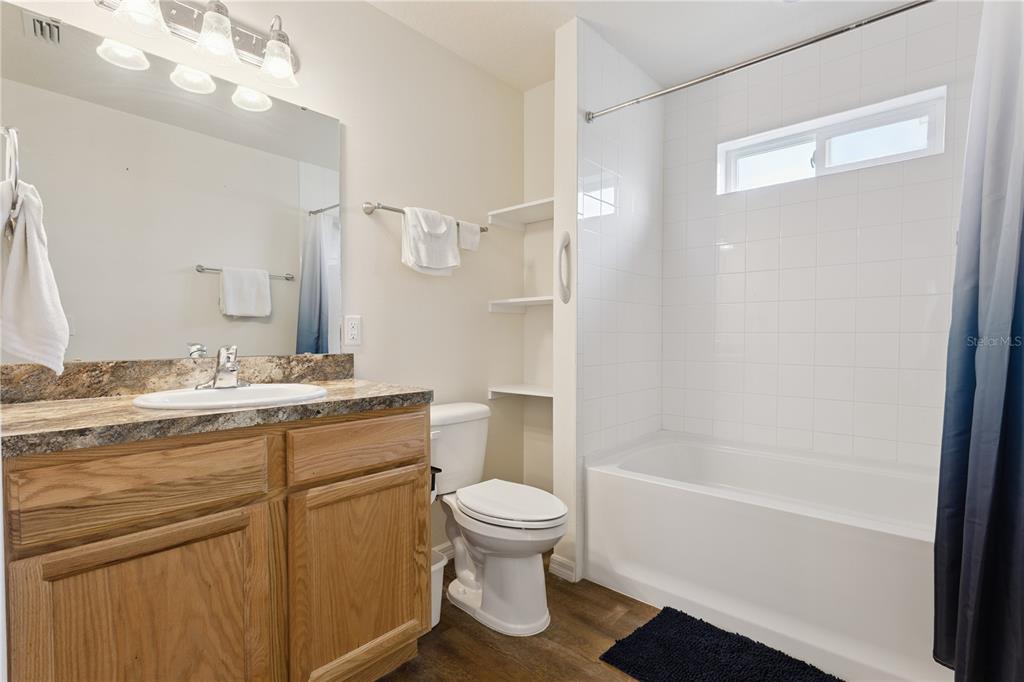 112 Turtle Run Umatilla, FL 32784 - Photo 15 of 32 a bathroom with a granite countertop sink toilet a large mirror a bathtub and shower
