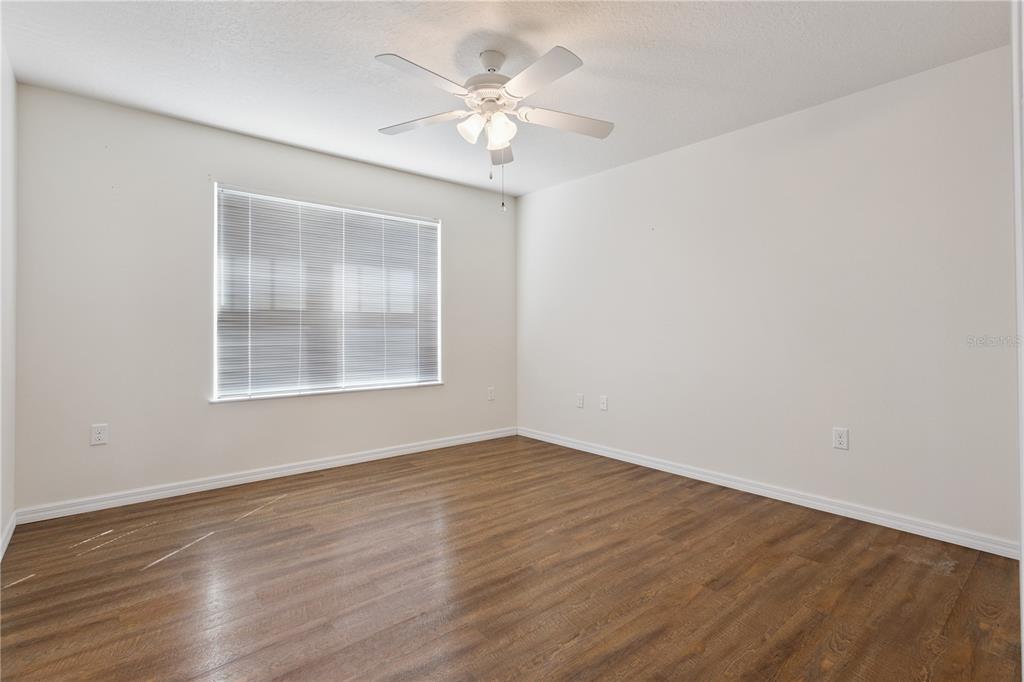 112 Turtle Run Umatilla, FL 32784 - Photo 17 of 32 a view of an empty room with wooden floor and a ceiling fan