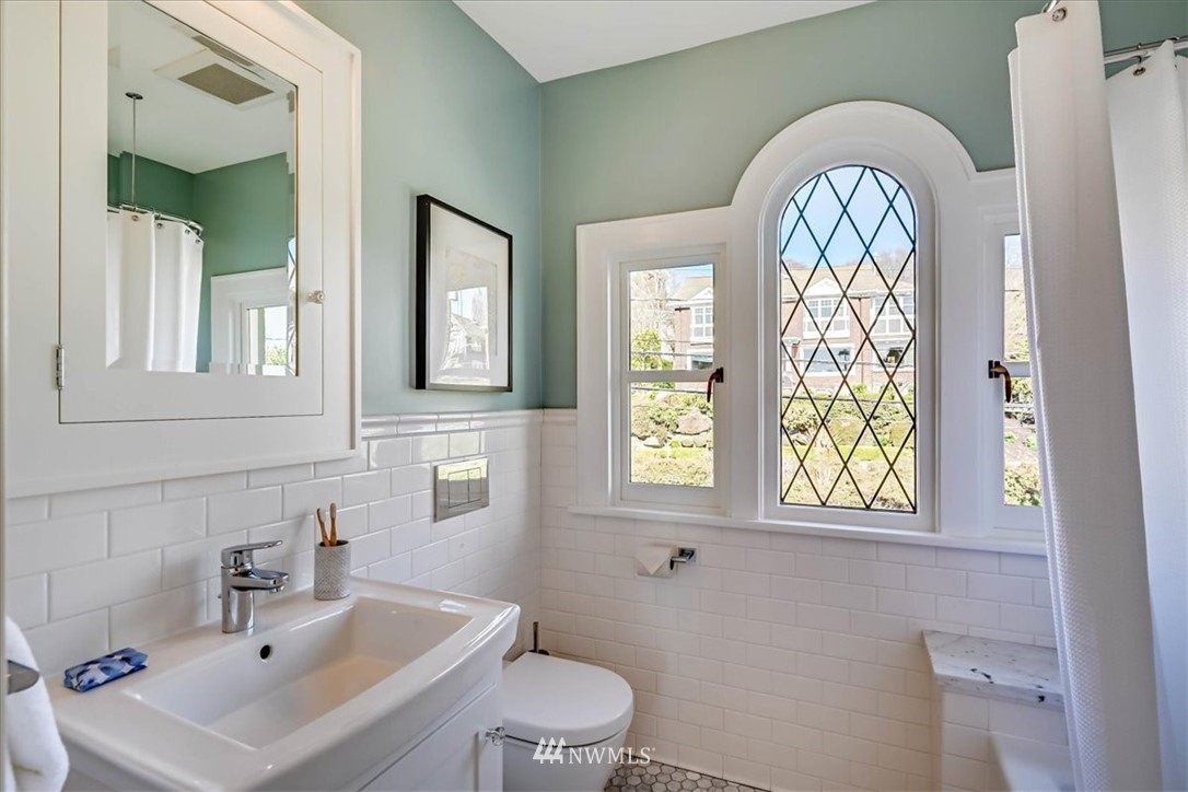 357 Highland Drive Seattle, WA 98109 - Photo 26 of 38 a bathroom with a sink a mirror and a toilet