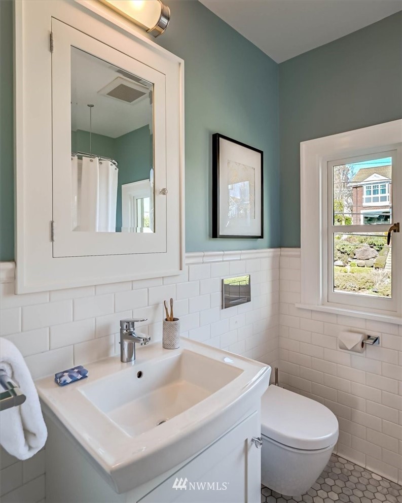 357 Highland Drive Seattle, WA 98109 - Photo 27 of 38 a bathroom with a sink a toilet and mirror