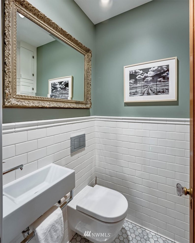 357 Highland Drive Seattle, WA 98109 - Photo 28 of 38 a bathroom with a toilet a sink and mirror