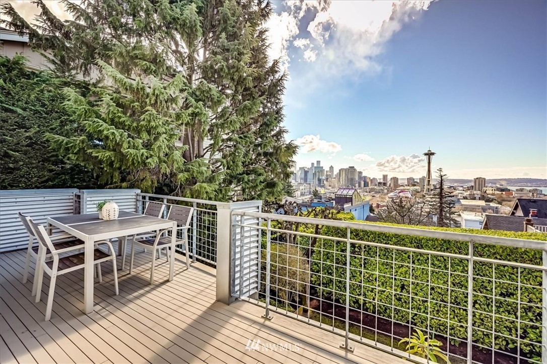 357 Highland Drive Seattle, WA 98109 - Photo 30 of 38 a view of a roof deck with table and chairs a barbeque with wooden floor and fence