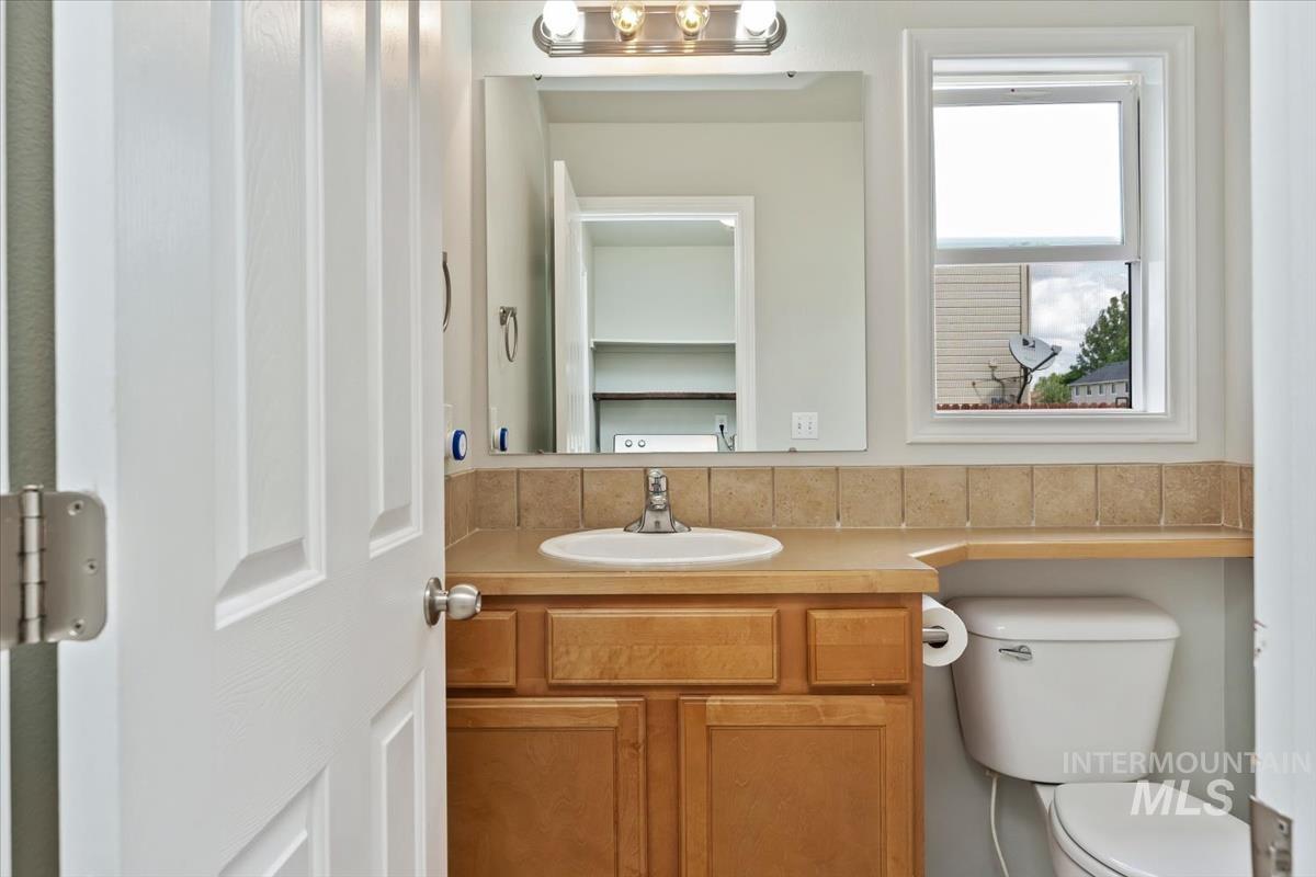 80 Cobblestone Court Middleton, ID 83644 - Photo 17 of 48 Bathroom featuring a wood-finish vanity with an integrated sink and a light-toned countertop