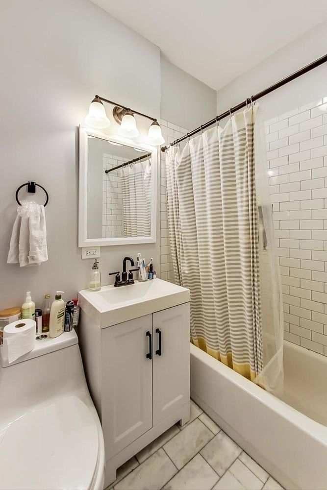 2025 West Melrose Street, Unit 2F Chicago, IL 60618 - Photo 13 of 18 a bathroom with a sink a mirror and a bathtub