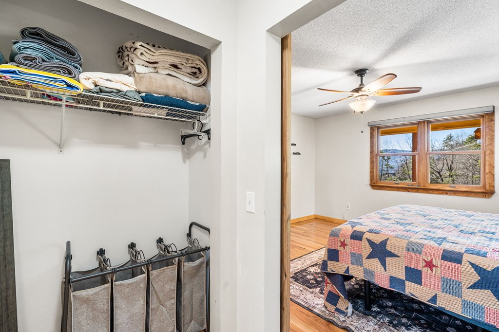 224 Shake Rag Road Hiawassee, GA 30546 - Photo 25 of 47 a bedroom with a bed and a chandelier