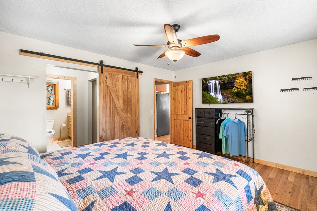 224 Shake Rag Road Hiawassee, GA 30546 - Photo 27 of 47 a bedroom with a bed and a chandelier