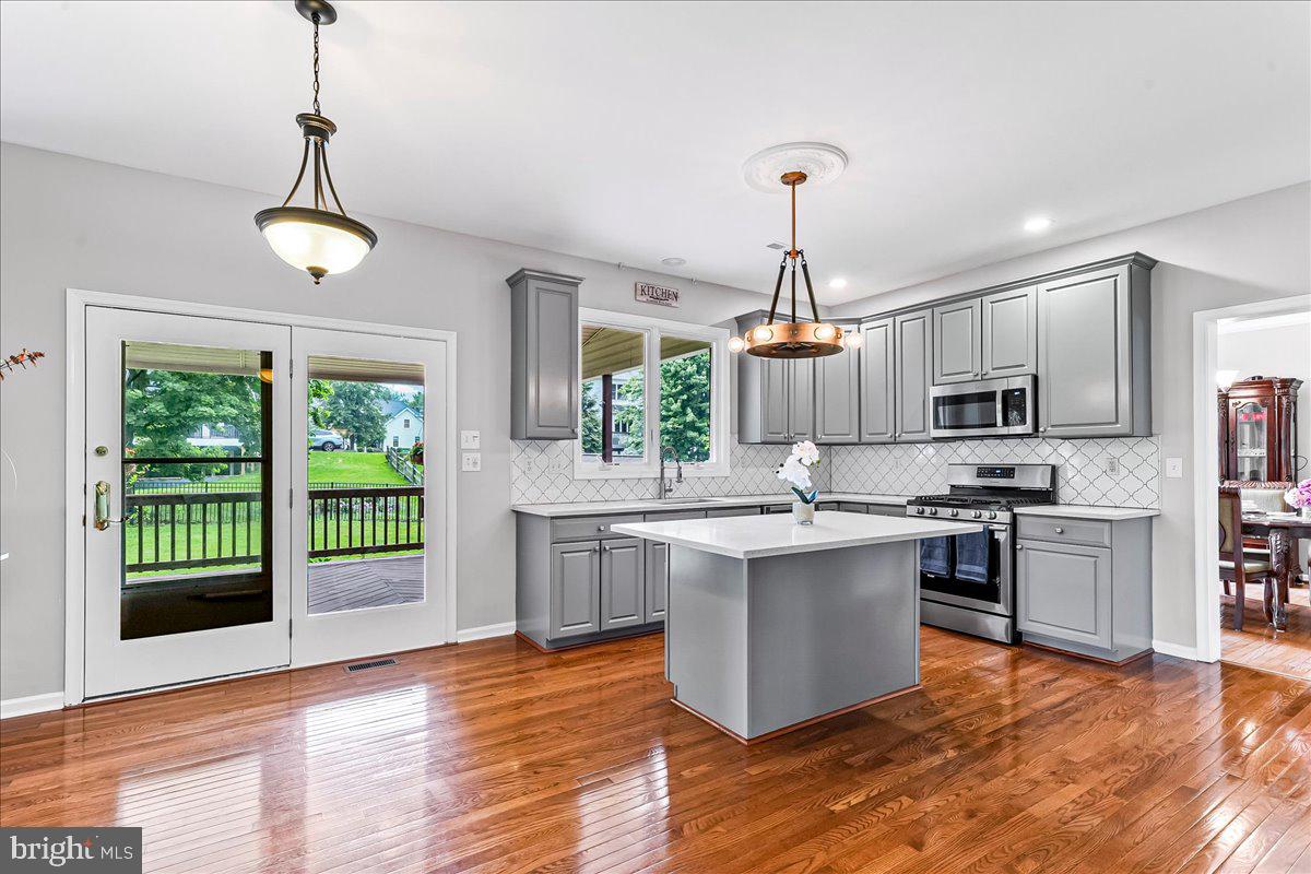 408 Brentford Road Kennett Square, PA 19348 - Photo 8 of 41 a kitchen with stainless steel appliances granite countertop a stove a sink dishwasher a refrigerator and a dining table with wooden floor