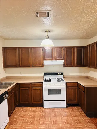 a kitchen with a stove sink and cabinets