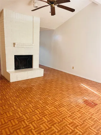 a view of a livingroom with a fireplace and a ceiling fan