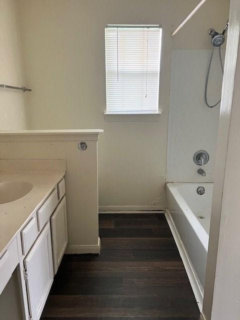 4409 Rattan Avenue Bay City, TX 77414 - Photo 11 of 13 a bathroom with a tub sink a mirror and shower