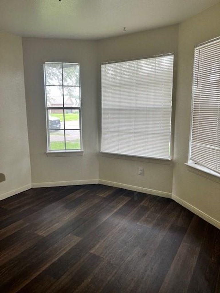 4409 Rattan Avenue Bay City, TX 77414 - Photo 5 of 13 an empty room with wooden floor and windows