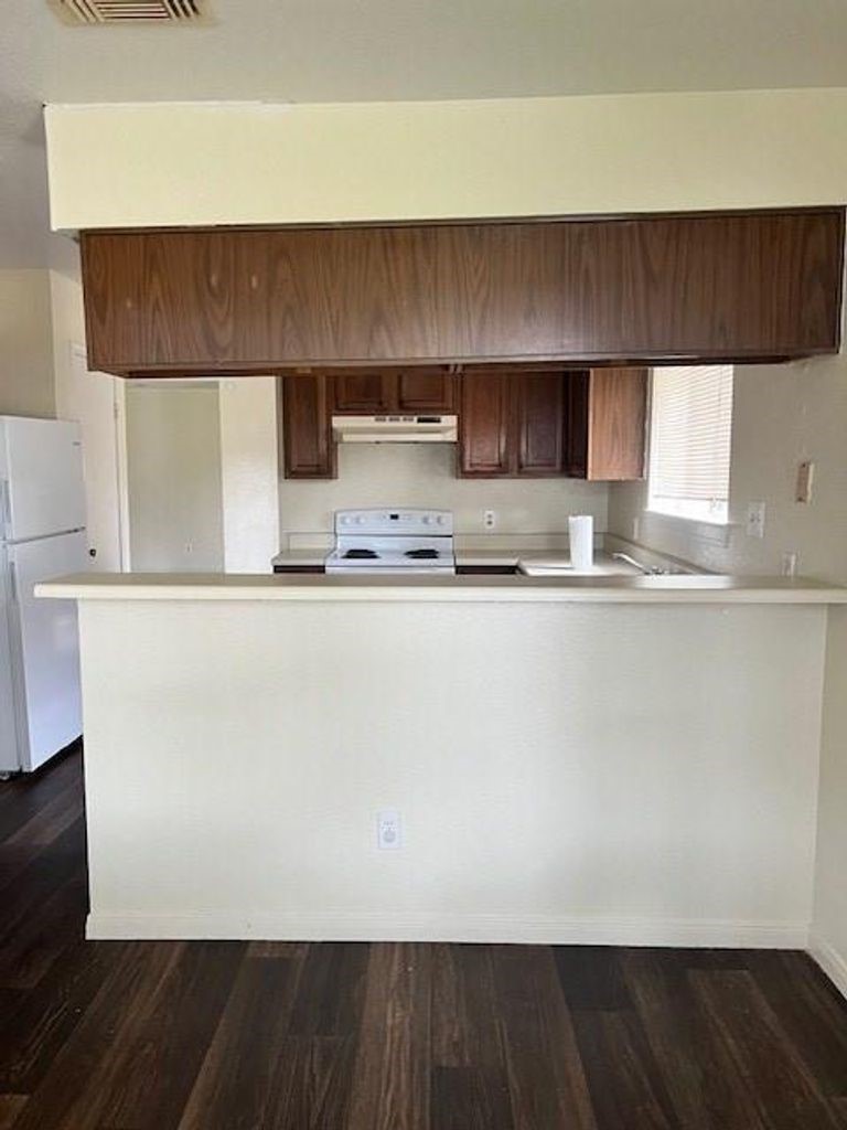 4409 Rattan Avenue Bay City, TX 77414 - Photo 6 of 13 a kitchen with a sink a microwave a refrigerator and cabinets