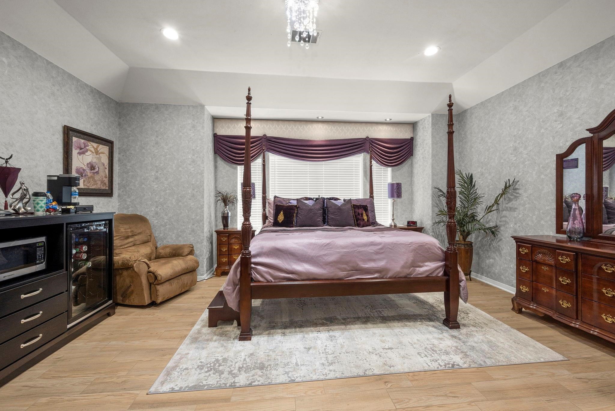 19525 Doerre Road Spring, TX 77379 - Photo 26 of 39 a bedroom with a bed a dresser and potted plants with the wooden floor