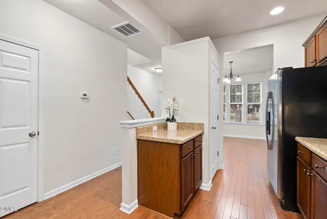 a kitchen with stainless steel appliances granite countertop a refrigerator a sink and a stove