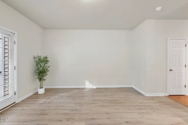 a view of an empty room with wooden floor