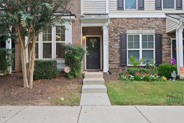 a front view of a house with a yard and potted plants