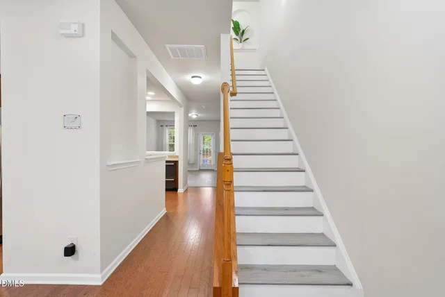 a view of a hallway with wooden floor and entryway