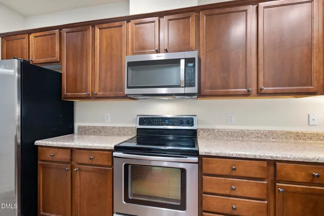 a kitchen with granite countertop wooden cabinets and a stove top oven