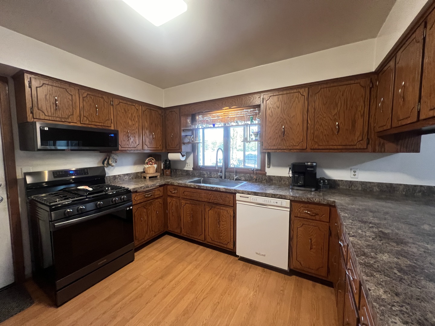 1380 South Regan Road New Lenox, IL 60451 - Photo 8 of 39 a kitchen with stainless steel appliances granite countertop wooden cabinets a stove a sink and a microwave