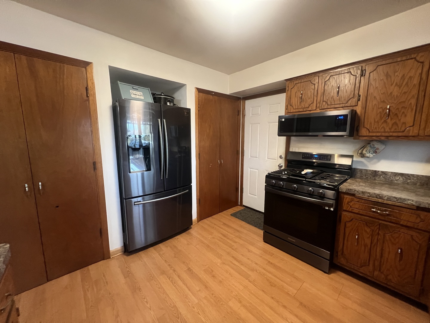 1380 South Regan Road New Lenox, IL 60451 - Photo 9 of 39 a kitchen with granite countertop a refrigerator stove and microwave