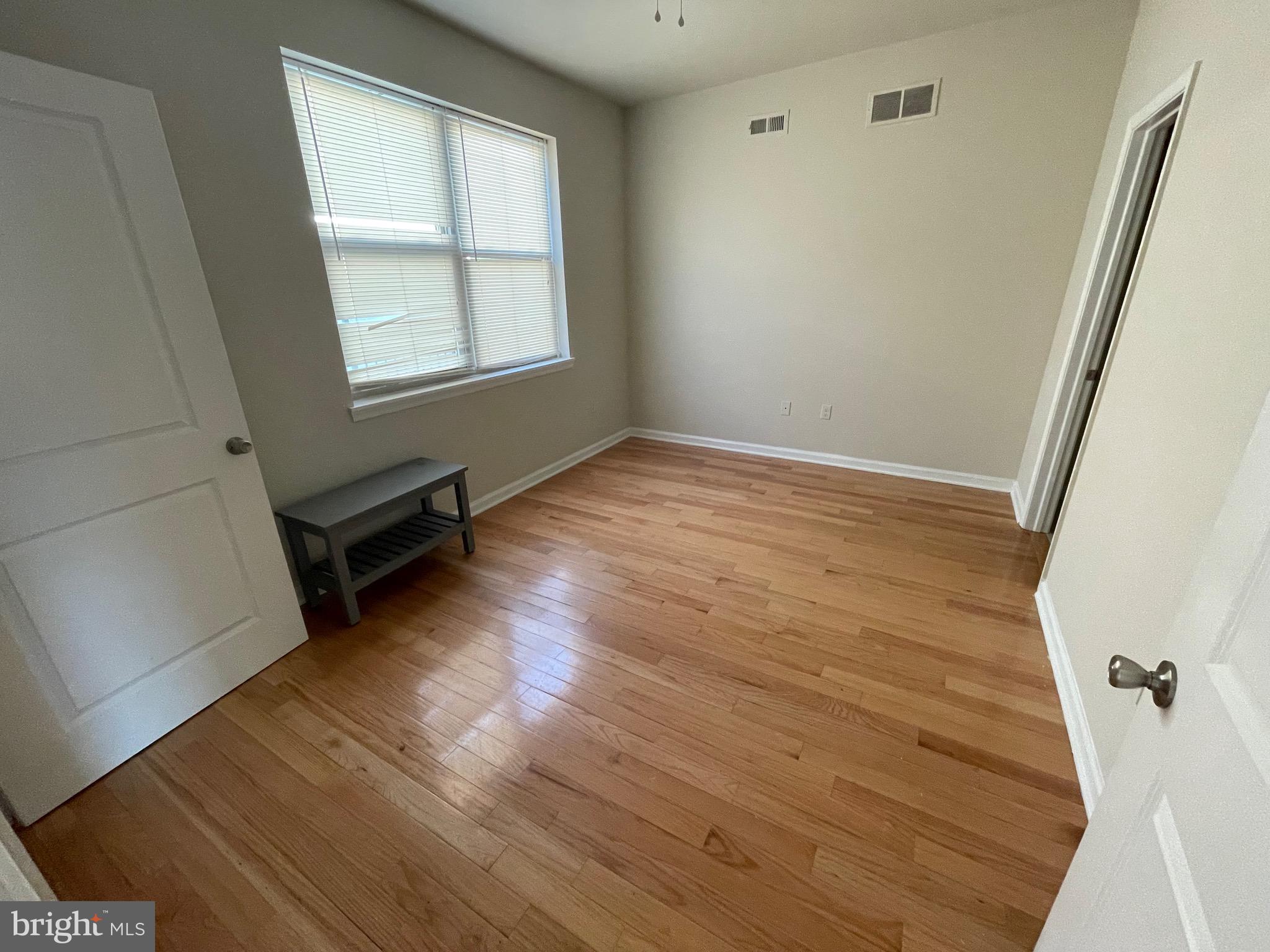 408 Wiota Street Philadelphia, PA 19104 - Photo 13 of 25 an empty room with wooden floor and windows