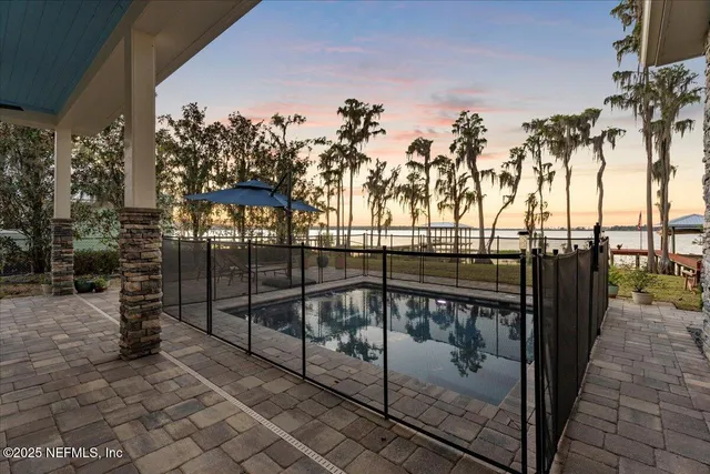 a dining room with wooden floor a chandelier a glass table and chairs