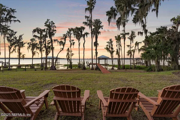 a living room with couches a fireplace and a table with garden view