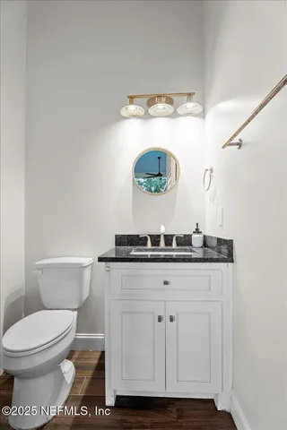 a bathroom with a granite countertop sink mirror vanity and toilet