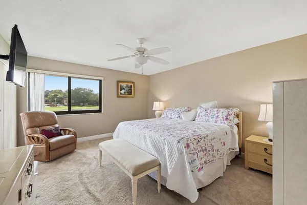 a spacious bedroom with a bed and a flat screen tv