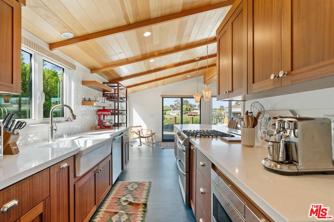 249 Paradise Cove Road Malibu, CA 90265 - Photo 12 of 41 a kitchen with sink stove and cabinets