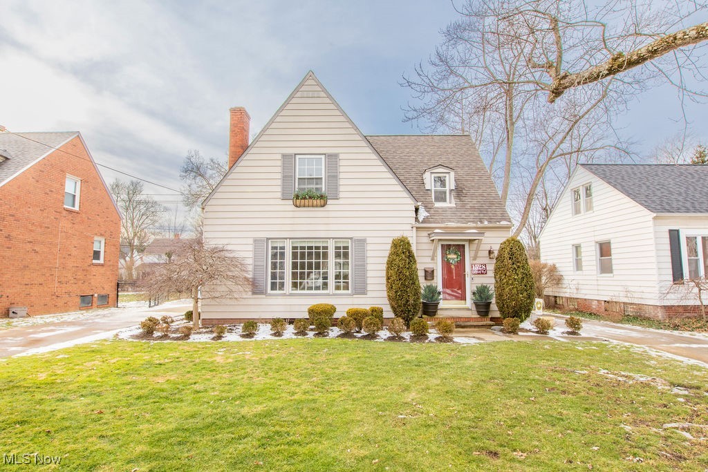 Front view of this charming bungalow, with professional landscaping and plenty of grass.