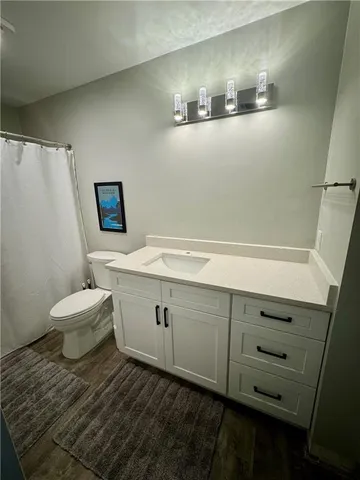 a view of a white house with a yard and large trees