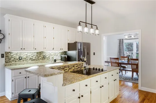 a kitchen with granite countertop a sink refrigerator and cabinets