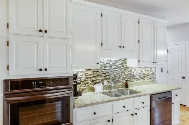 a kitchen with granite countertop white cabinets and white appliances