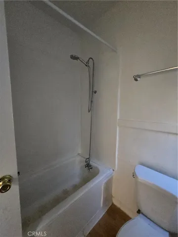 a bath tub sitting next to a white toilet and a shower